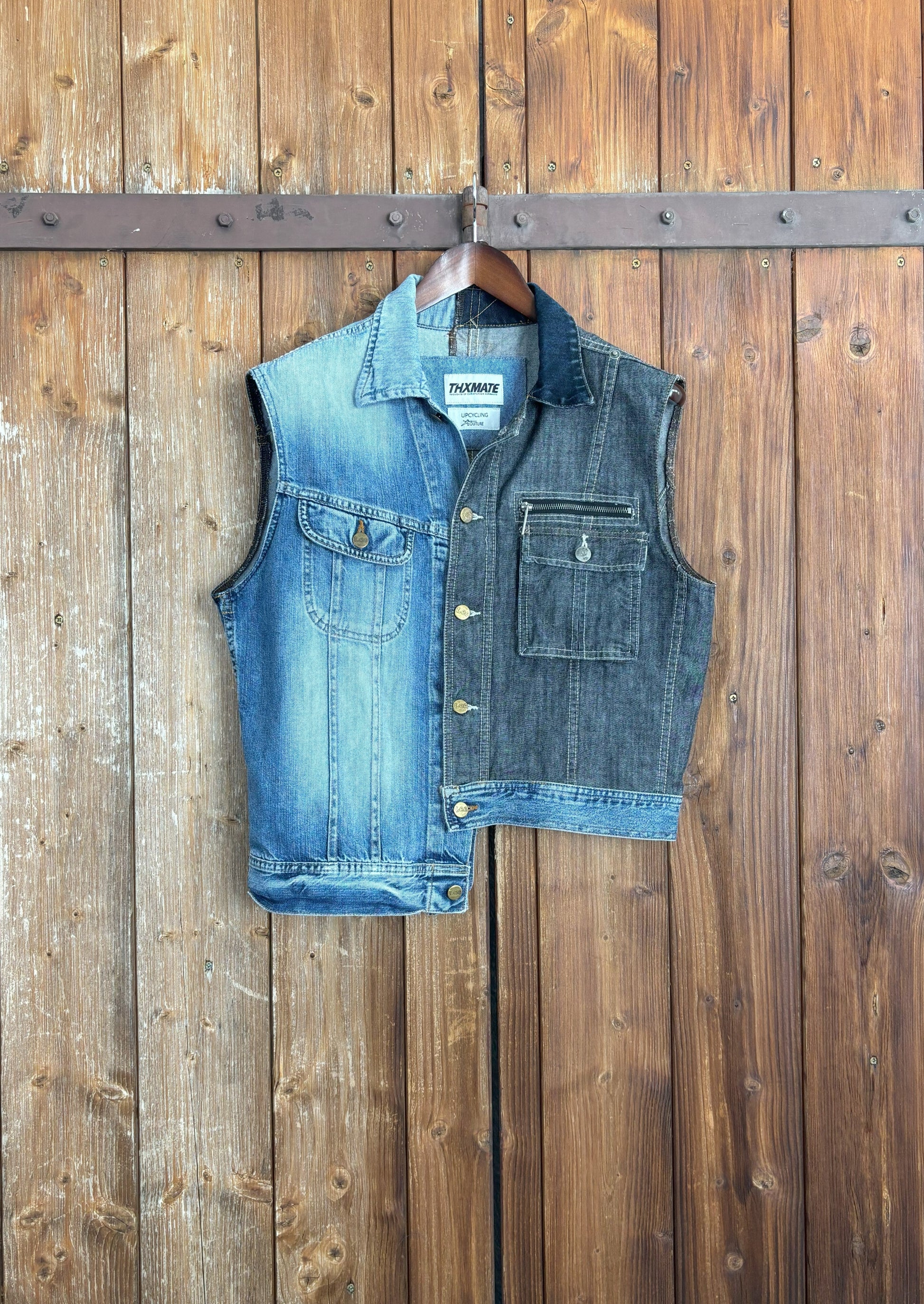 Eine einzigartige, asymmetrische Jeansweste, die aus einer hellblauen und einer dunkelblauen Jeansjacke zusammengesetzt ist. Die Weste hat einen hellblauen Abschluss, der die beiden Farben harmonisch verbindet. Die verfügt über einen Knopfverschluss und zwei Brusttaschen, die ebenfalls einen Knopfverschluss haben.