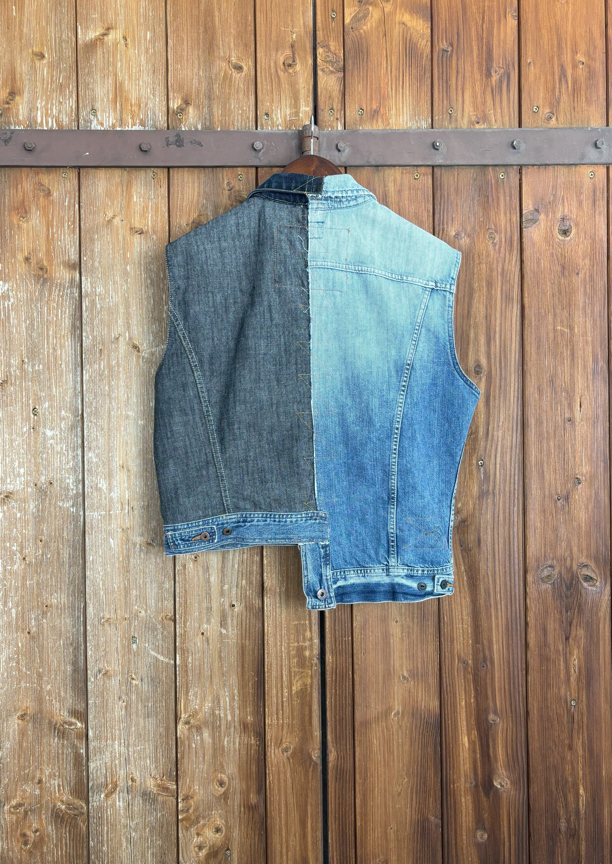 Die Rückseite der einzigartigen, asymmetrischen Jeansweste zeigt die Kombination aus einer hellblauen und einer dunkelblauen Jeansjacke mit hellblauem Abschluss.