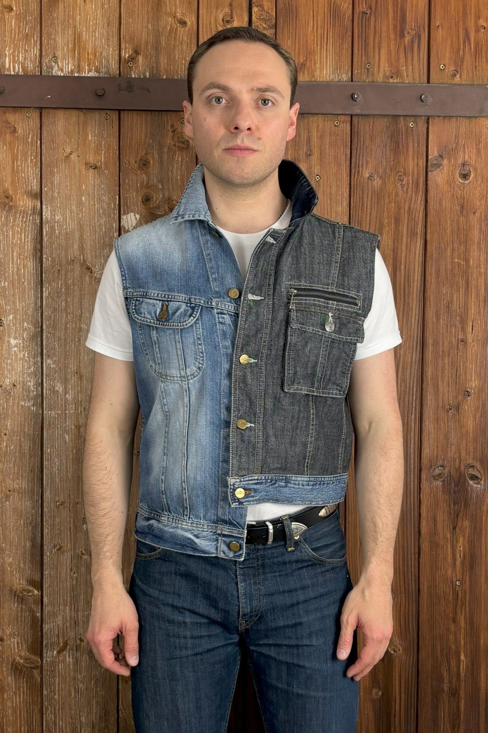 Eine einzigartige, asymmetrische Jeansweste, die aus einer hellblauen und einer dunkelblauen Jeansjacke zusammengesetzt ist. Die Weste hat einen hellblauen Abschluss, der die beiden Farben harmonisch verbindet. Die verfügt über einen Knopfverschluss und zwei Brusttaschen, die ebenfalls einen Knopfverschluss haben.